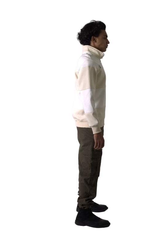 Person wearing a white hoodie and dark pants against a plain background