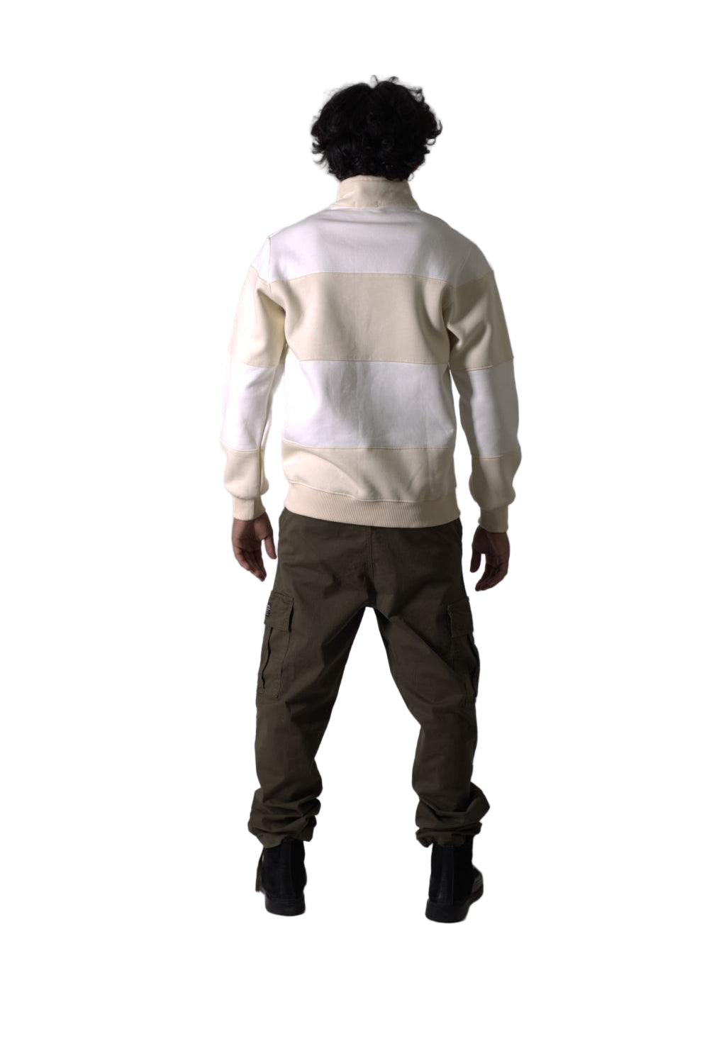 Mannequin wearing a white sweater and brown pants on a plain background