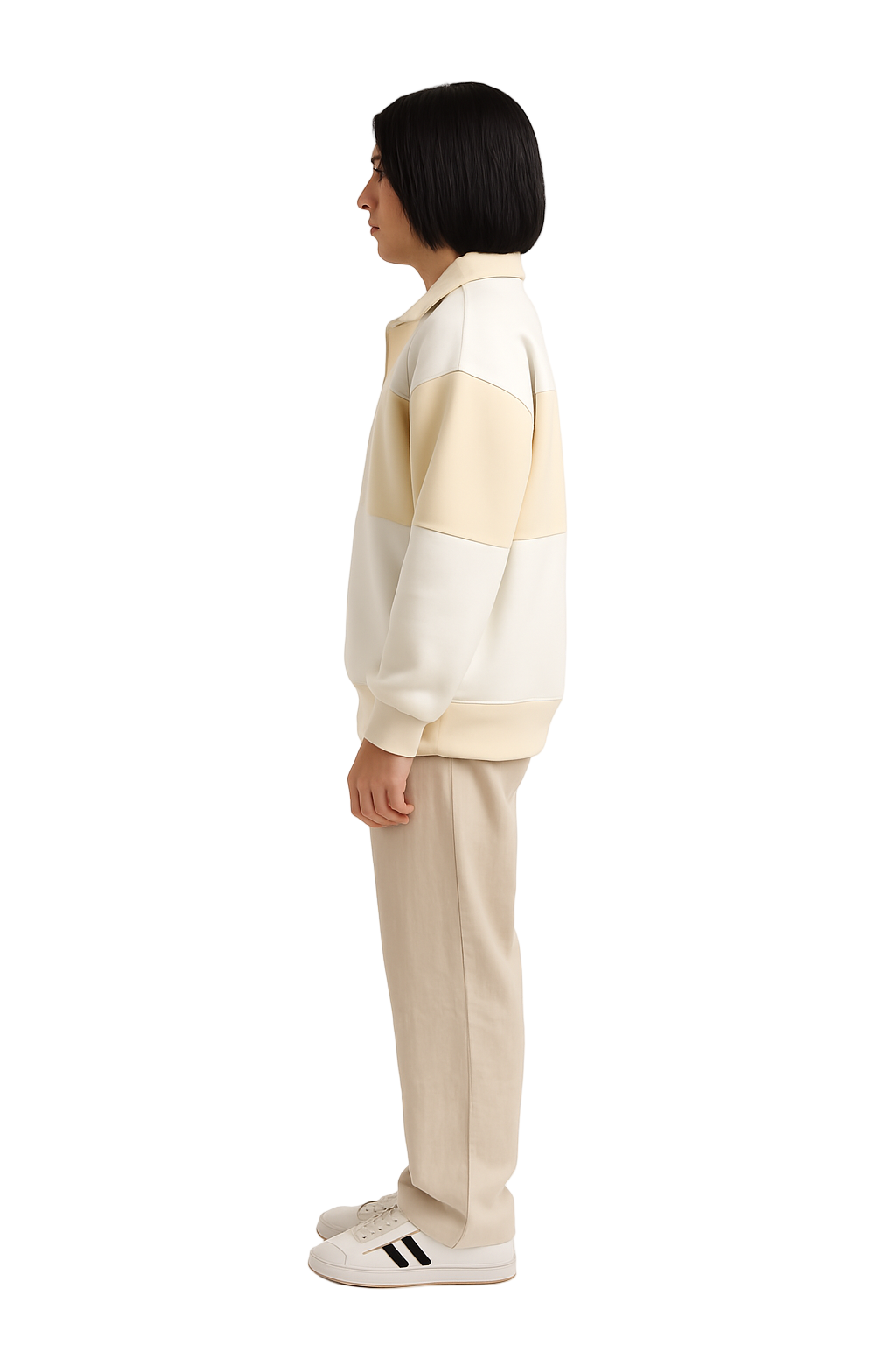 Person wearing a cream and beige color-blocked sweater with beige pants on a white background