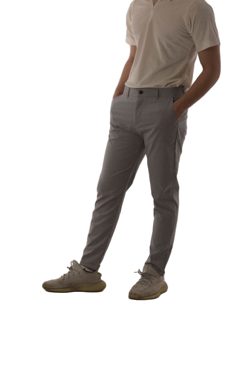 Person wearing gray pants and beige shoes on a plain white background