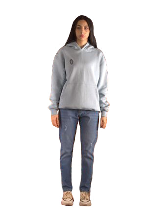 Person wearing a light gray sweatshirt and dark jeans standing on a brown leather couch with a patterned rug underneath.