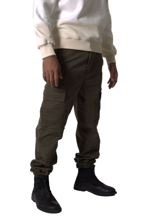 Person wearing dark pants and black shoes on a white background