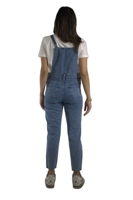Person wearing a white shirt and blue overalls on a plain background