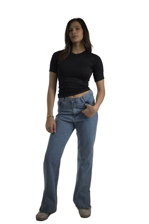 Person wearing blue jeans and a black shirt on a plain background