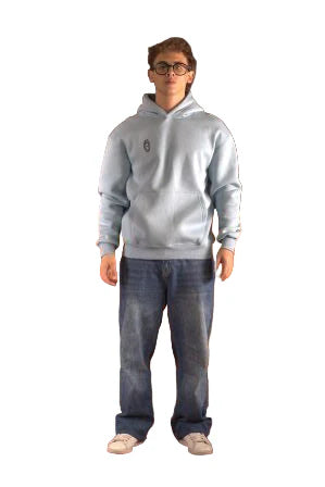 Person wearing a light gray sweatshirt and dark jeans standing on a brown leather couch with a patterned rug.