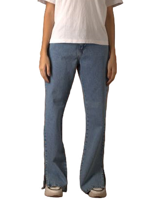 Person wearing blue jeans standing in front of a brown leather couch.