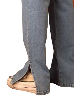 Person wearing blue jeans and tan shoes on a patterned rug
